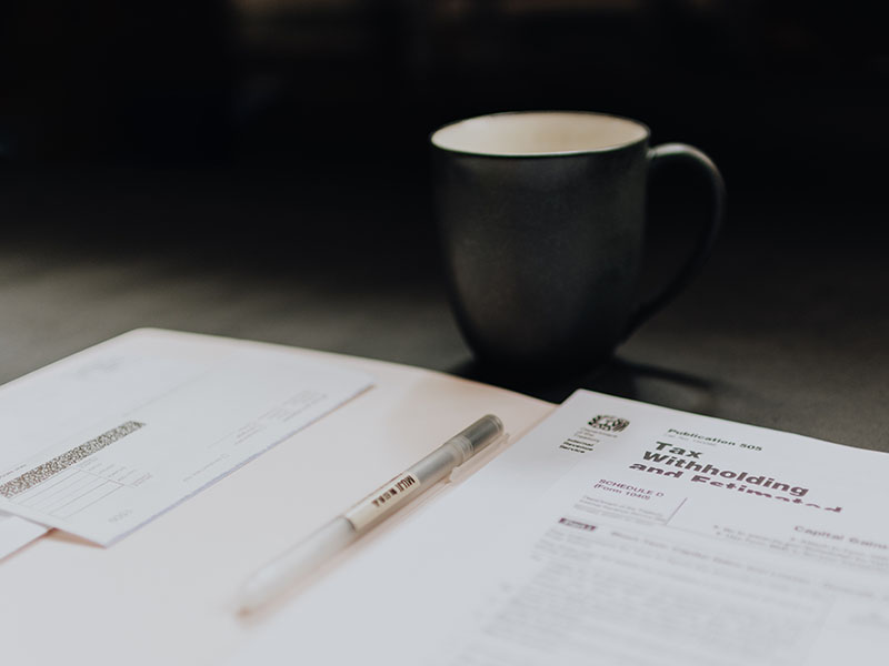 coffee cup next to tax documents