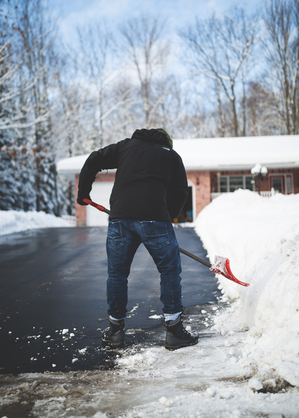 Man shoveling snow in driveway