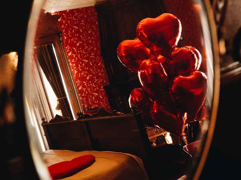 Red heart-shaped balloons in a bedroom