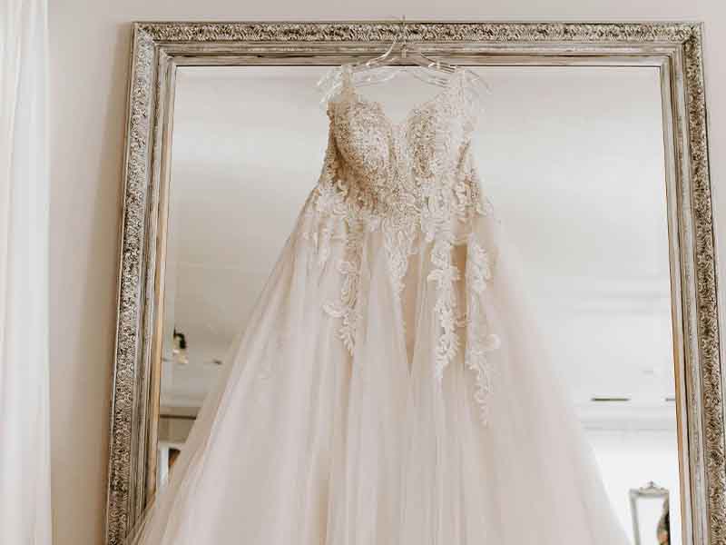 White wedding dress hanging on a mirror