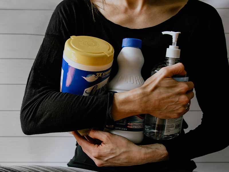 Woman holding cleaning supplies