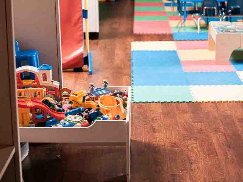 Playroom with bins of toys and colorful rug