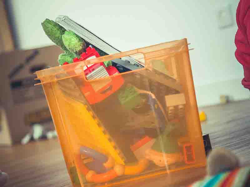 Orange storage bin with toys inside