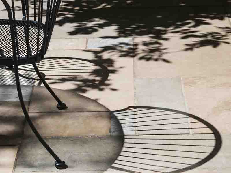 Shadow of chairs and table on stone patio floor
