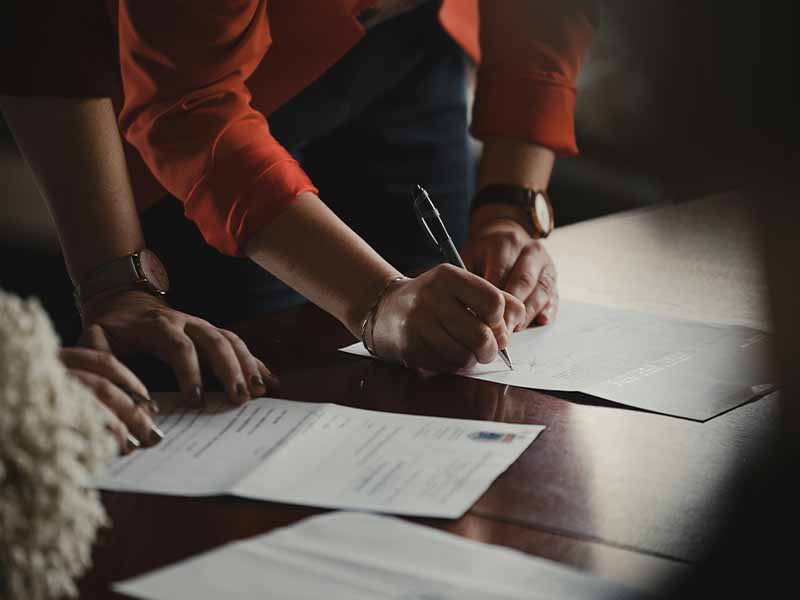 People signing paperwork