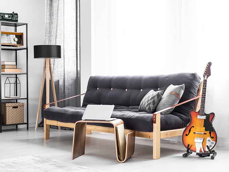 Gray room with couch, guitar, and laptop shown