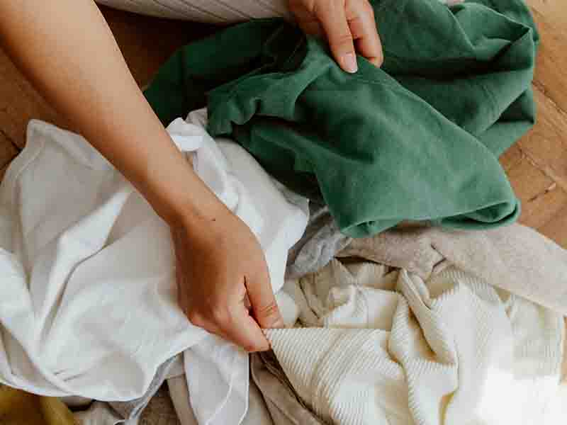 Person sorting a pile of clothes