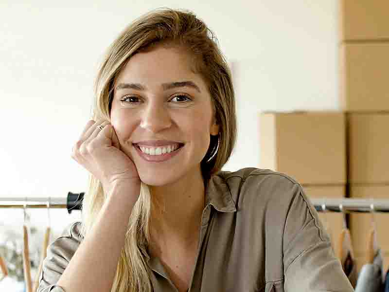 Woman smiling with boxes in background