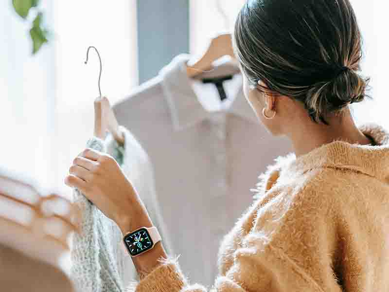 Woman trying to decide between two different shirts 