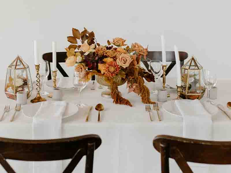 Floral table arrangement, dishes and candles