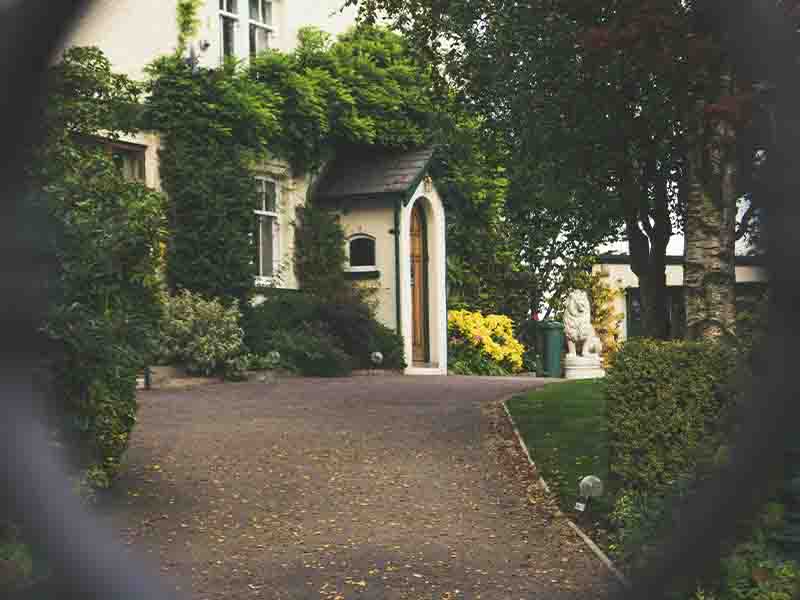 Longshot of home through an iron fence