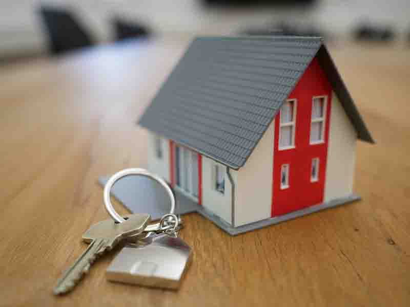 miniature home with house keys next to it