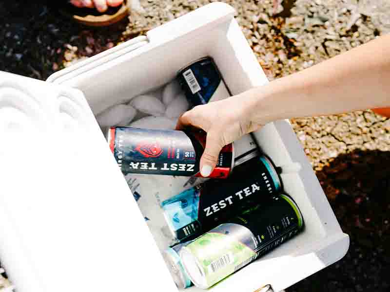 Someone grabbing tea from cooler