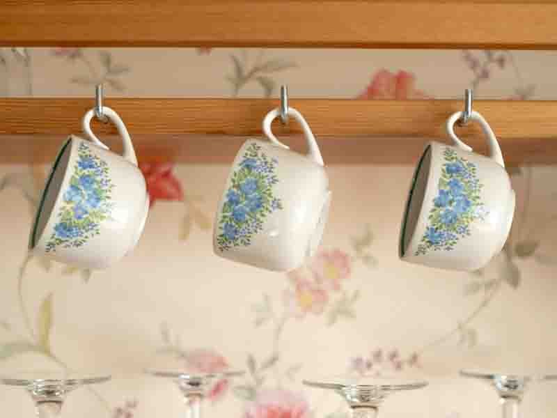 Vintage teacups hanging on hooks
