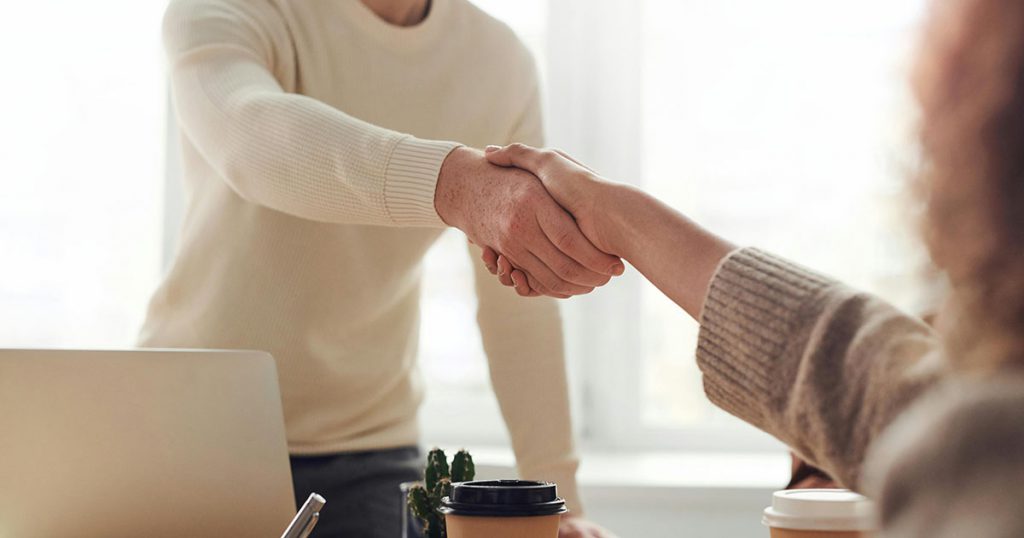 a realtor shaking hands with a new home buyer