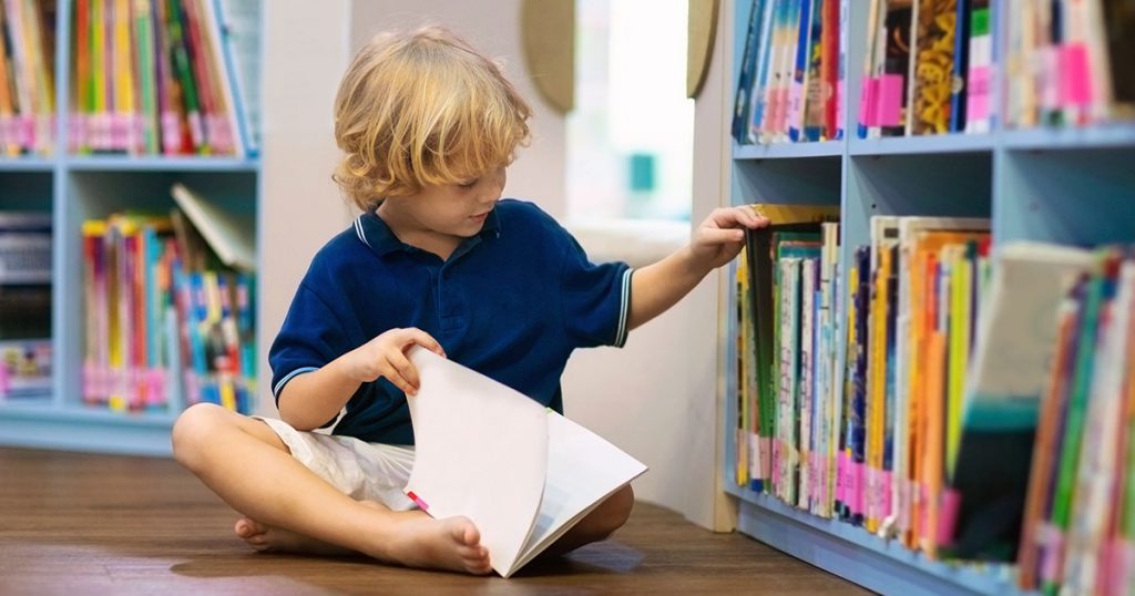 a child looking through a bookshelf