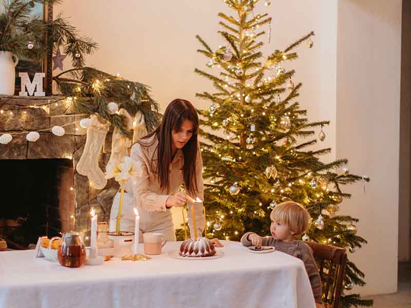 Family eating holiday dinner with tree and lights in background