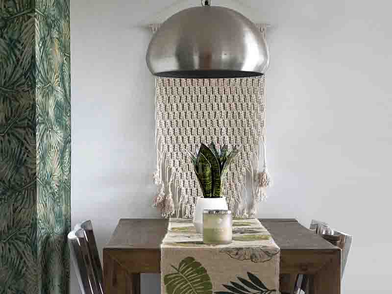 Dining room with crocheted wall hanging and palm print