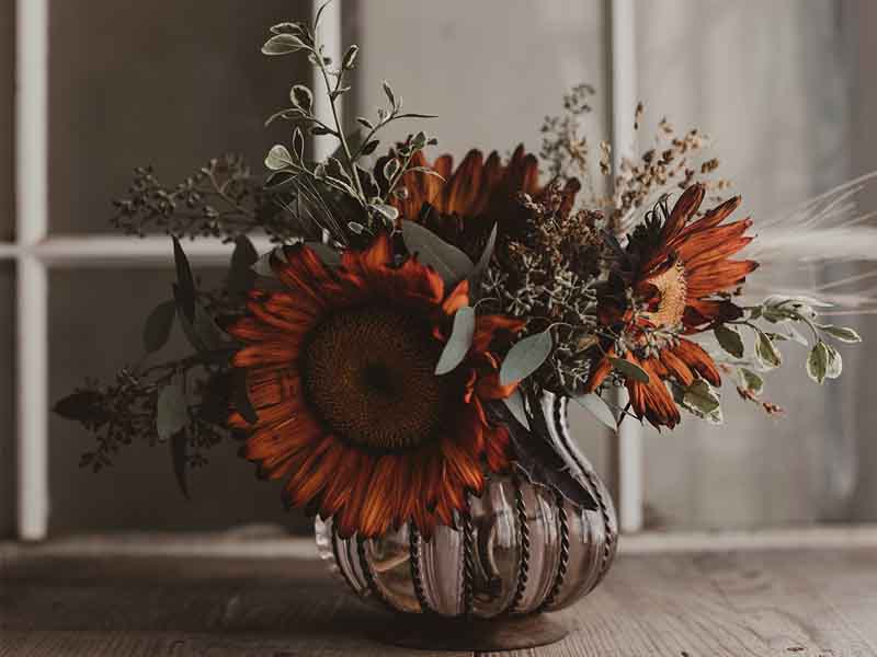 Fall bouquet with orange flowers and pewter vase