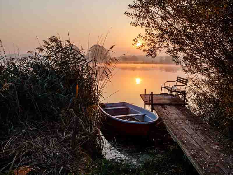 Boat parked next to a small dock on a lake