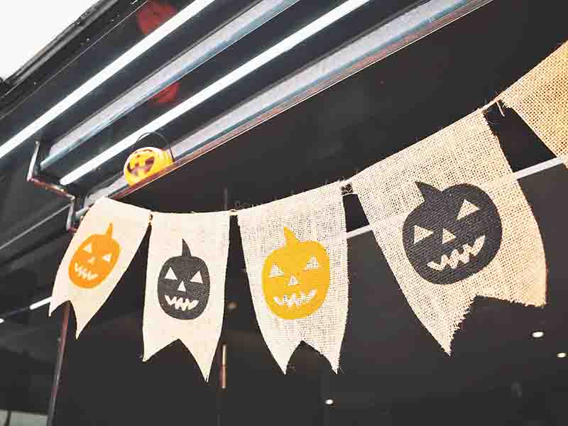 Pumpkin flags hanging from porch roof