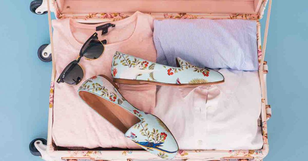 Suitcase with pink and purple pastel clothing